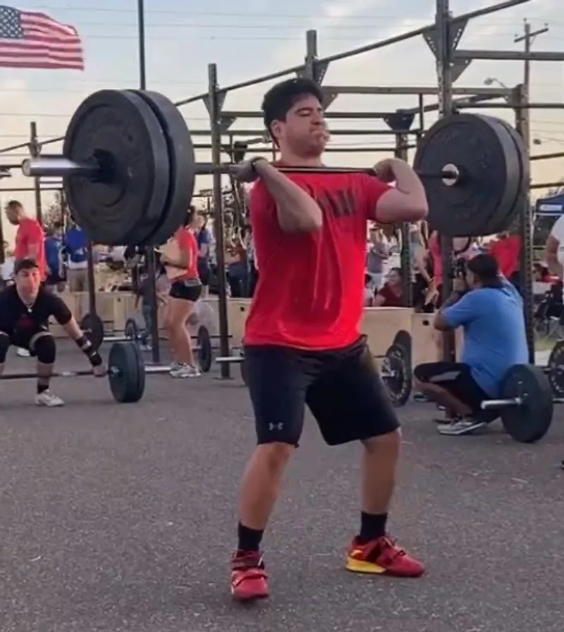 An athlete standing tall after a clean during a competition